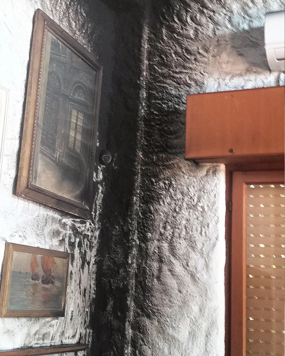 Parete annerita dalla fuliggine dopo un incendio, prima del ripristino